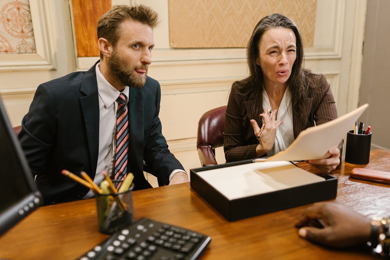 gallery-4 Lawyers discussing legal documents in a professional office setting.